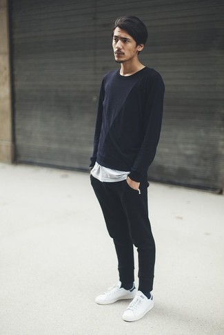 Comment porter un pantalon de jogging noir avec des baskets basses en cuir blanches
