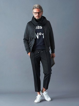 Comment porter un pantalon de jogging noir avec des baskets basses en cuir blanches