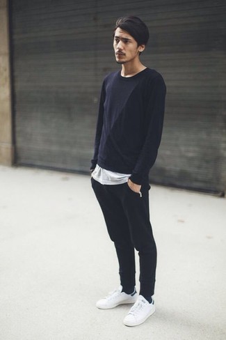 Comment porter un pantalon de jogging noir avec des baskets basses en cuir blanches