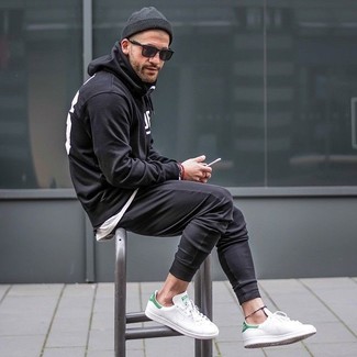 Comment porter un pantalon de jogging noir avec des baskets basses en cuir blanches
