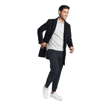 Comment porter un pantalon de jogging noir avec des baskets basses en cuir blanches