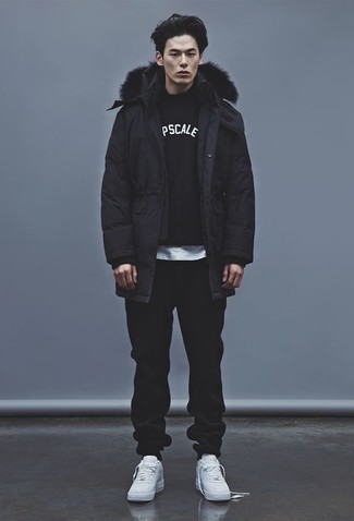 Comment porter un pantalon de jogging noir avec des baskets basses en cuir blanches