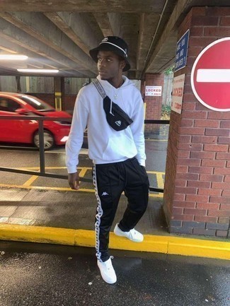 Comment porter un pantalon de jogging noir avec des baskets basses en cuir blanches