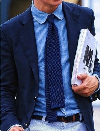 Comment porter une chemise à manches longues en chambray bleue: La polyvalence d'une chemise à manches longues en chambray bleue et d'un pantalon chino blanc en fait des pièces de valeur sûre.