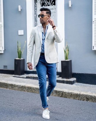 Comment porter un blazer gris: Porte un blazer gris et un jean bleu pour aller au bureau. Jouez la carte décontractée pour les chaussures et fais d'une paire de baskets basses en toile blanches ton choix de souliers.