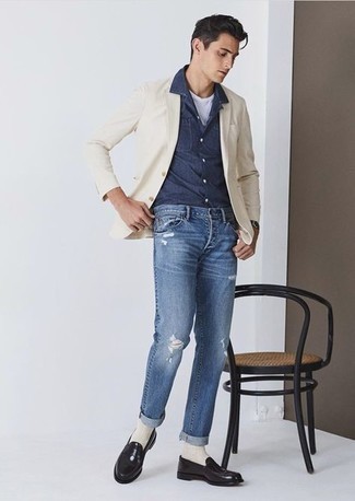 Comment porter un blazer beige: Pense à associer un blazer beige avec un jean déchiré bleu pour obtenir un look relax mais stylé. Complète cet ensemble avec une paire de slippers en cuir noirs pour afficher ton expertise vestimentaire.