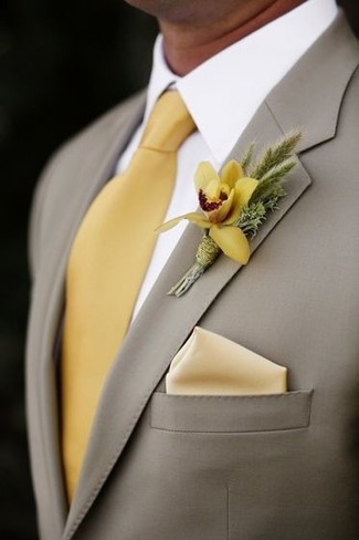 Comment porter une cravate en soie jaune: Pense à opter pour un blazer gris et une cravate en soie jaune pour dégager classe et sophistication.
