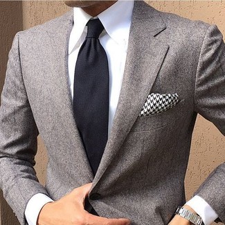 Comment porter une pochette de costume en pied-de-poule noire et blanche: Opte pour un blazer gris avec une pochette de costume en pied-de-poule noire et blanche pour une tenue relax mais stylée.