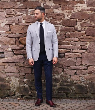 Comment porter un blazer gris: Sois au sommet de ta classe en portant un blazer gris et un pantalon de costume bleu marine. Cet ensemble est parfait avec une paire de slippers en cuir bordeaux.