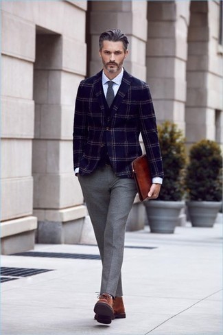 Comment porter une pochette en cuir marron: Essaie d'associer un blazer écossais bleu marine avec une pochette en cuir marron pour un look idéal le week-end. Une paire de bottines chukka en daim marron est une façon simple d'améliorer ton look.