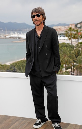 Tenue de Pierpaolo Piccioli: Blazer croisé noir, Chemise à manches longues noire, Pantalon de costume noir, Baskets basses en toile noires et blanches