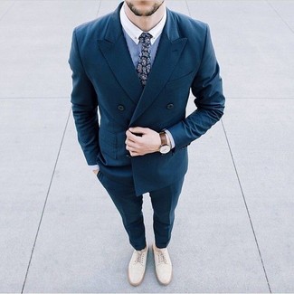 Comment porter une cravate imprimée cachemire bleue: Choisis un blazer croisé bleu canard et une cravate imprimée cachemire bleue pour un look pointu et élégant. Si tu veux éviter un look trop formel, opte pour une paire de chaussures brogues en daim blanches.