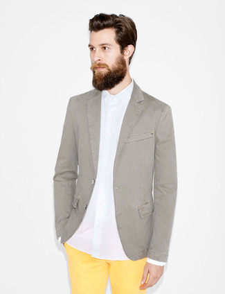 Comment porter un blazer en coton gris foncé: Porte un blazer en coton gris foncé et un pantalon chino jaune pour aller au bureau.