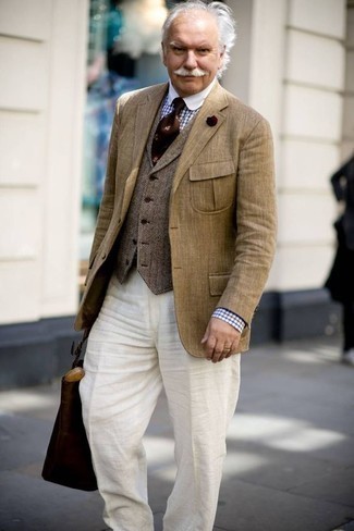 Comment porter un gilet en laine à chevrons marron: Pense à associer un gilet en laine à chevrons marron avec un pantalon de costume en lin blanc pour un look classique et élégant.