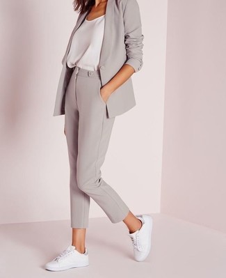 Comment porter un blazer gris: Marie un blazer gris avec un pantalon slim gris pour une tenue idéale le week-end. Jouez la carte décontractée pour les chaussures et opte pour une paire de baskets basses en cuir blanches.