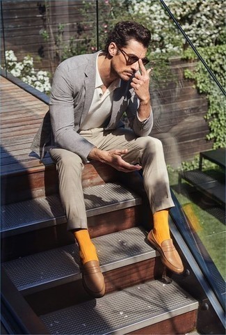 Comment porter des slippers en cuir marron clair: Associe un blazer gris avec un pantalon chino beige pour créer un look chic et décontracté. Jouez la carte classique pour les chaussures et termine ce look avec une paire de slippers en cuir marron clair.