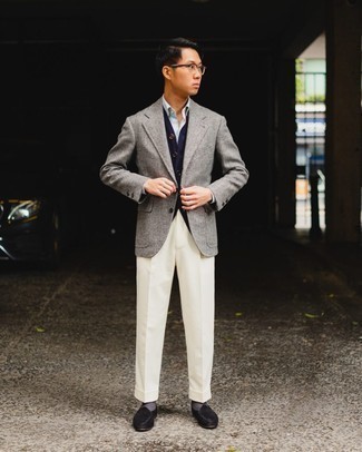 Comment porter un blazer en laine gris: Essaie d'harmoniser un blazer en laine gris avec un pantalon de costume blanc pour une silhouette classique et raffinée. Cette tenue est parfait avec une paire de slippers en daim noirs.