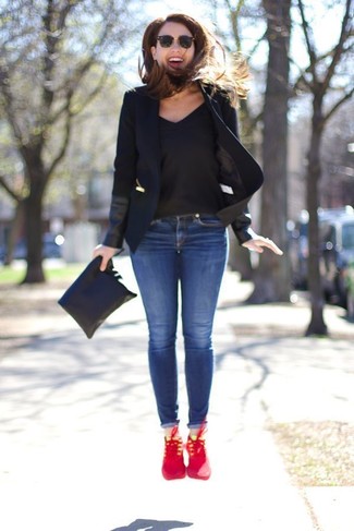 Comment porter un t-shirt à col en v noir: Associe un t-shirt à col en v noir avec un jean skinny bleu pour obtenir un look relax mais stylé. Tu veux y aller doucement avec les chaussures? Opte pour une paire de chaussures de sport rouges pour la journée.