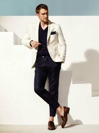 Tenue: Blazer blanc, T-shirt à col en v bleu marine, Pantalon de costume bleu marine, Slippers en cuir marron foncé