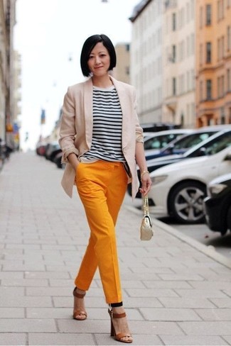 Tenue: Blazer beige, T-shirt à col rond à rayures horizontales blanc et noir, Pantalon carotte orange, Sandales à talons en cuir marron