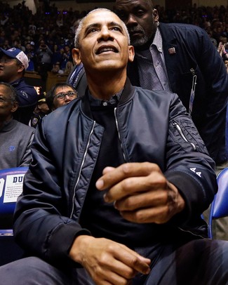Tenue de Barack Obama: Blouson aviateur bleu marine, Pull à col rond noir, Chemise à manches longues à rayures verticales noire, Pantalon chino gris foncé