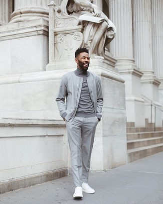Comment porter un pantalon de costume gris: Harmonise un blouson aviateur gris avec un pantalon de costume gris pour un look pointu et élégant. D'une humeur créatrice? Assortis ta tenue avec une paire de baskets basses en toile blanches.