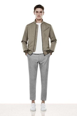 Tenue: Blouson aviateur marron, T-shirt à col rond blanc, Pantalon chino gris, Baskets basses en toile blanches