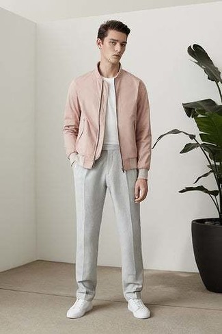 Tenue: Blouson aviateur rose, T-shirt à col rond blanc, Pantalon chino gris, Baskets basses en toile blanches