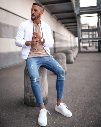Comment porter un jean skinny déchiré bleu: Opte pour un blouson aviateur blanc avec un jean skinny déchiré bleu pour une tenue idéale le week-end. Transforme-toi en bête de mode et fais d'une paire de baskets basses en toile blanches ton choix de souliers.