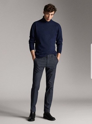 Un pull à col roulé à porter avec un pantalon chino gris foncé