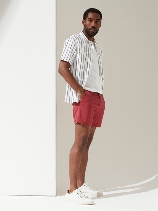 Comment porter un short rouge: Associe une chemise à manches courtes à rayures verticales blanche et noire avec un short rouge pour obtenir un look relax mais stylé. Cette tenue est parfait avec une paire de baskets basses en toile blanches.
