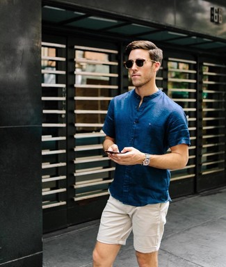 Comment porter une chemise à manches courtes bleu marine avec un short beige en été: Porte une chemise à manches courtes bleu marine et un short beige pour un look de tous les jours facile à porter. Cette tenue est juste top et parfaite pour l'été.