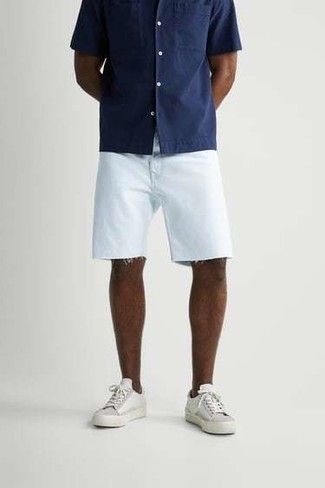 Comment porter une chemise à manches courtes bleu marine: Essaie d'harmoniser une chemise à manches courtes bleu marine avec un short en denim blanc pour affronter sans effort les défis que la journée te réserve. Termine ce look avec une paire de baskets basses en toile blanches.