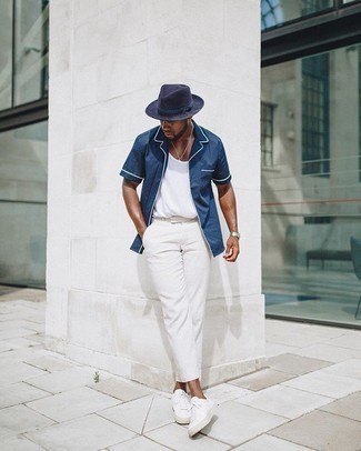 Comment porter un chapeau bleu marine: Pour une tenue aussi confortable que ton canapé, associe une chemise à manches courtes bleu marine avec un chapeau bleu marine. Rehausse cet ensemble avec une paire de baskets basses en toile blanches.