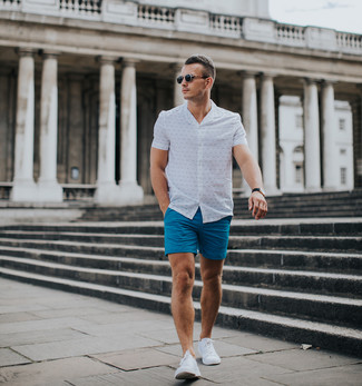 Comment porter un short bleu: Essaie d'associer une chemise à manches courtes imprimée blanche avec un short bleu pour une tenue idéale le week-end. Assortis ce look avec une paire de baskets basses blanches.