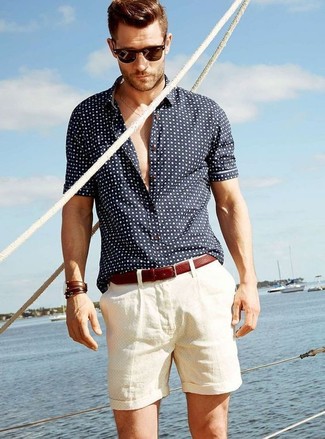Comment porter une chemise à manches courtes á pois bleu marine en été: Porte une chemise à manches courtes á pois bleu marine et un short beige pour une tenue idéale le week-end. C'est une tenue plutôt estivale.