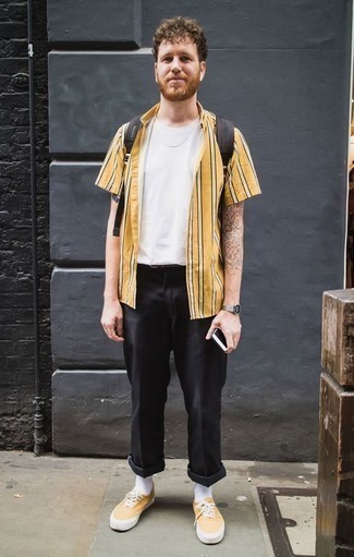 Tenue: Chemise à manches courtes à rayures verticales jaune, T-shirt à col rond blanc, Pantalon chino noir, Baskets basses en toile jaunes