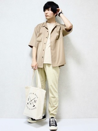 Tenue: Chemise à manches courtes marron clair, T-shirt à col rond beige, Pantalon chino beige, Baskets basses en toile noires et blanches
