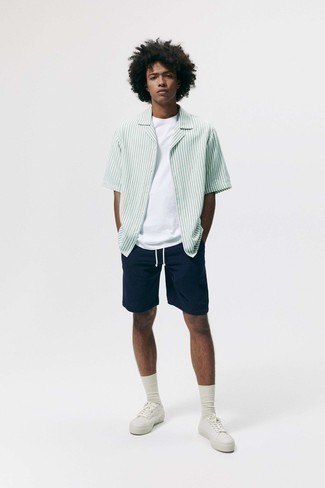 Tenue: Chemise à manches courtes à rayures verticales blanc et vert, T-shirt à col rond blanc, Short bleu marine, Baskets basses en toile blanches