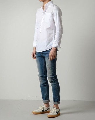 Comment porter un jean bleu avec une chemise blanche à 20 ans: Harmonise une chemise blanche avec un jean bleu pour une tenue idéale le week-end. Assortis cette tenue avec une paire de baskets basses en toile blanc et bleu marine pour afficher ton expertise vestimentaire.