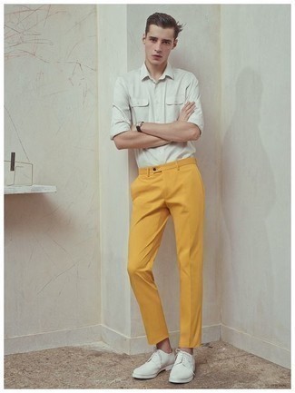 Comment porter un pantalon chino orange: Associe une chemise à manches longues blanche avec un pantalon chino orange pour une tenue idéale le week-end. Opte pour une paire de chaussures derby en cuir blanches pour afficher ton expertise vestimentaire.