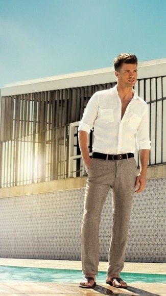 Comment porter un pantalon de costume gris pour un style decontractés: Opte pour une chemise à manches longues blanche avec un pantalon de costume gris pour un look pointu et élégant. Une paire de sandales en cuir marron foncé apportera un joli contraste avec le reste du look.
