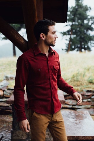Comment porter une chemise rouge pour un style chic decontractés: La polyvalence d'une chemise rouge et d'un pantalon chino marron en fait des pièces de valeur sûre.