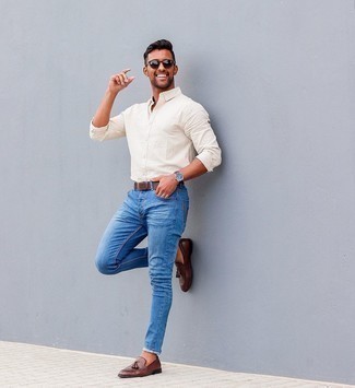 Comment porter un jean bleu avec des slippers en cuir marron à 30 ans: Pour créer une tenue idéale pour un déjeuner entre amis le week-end, marie une chemise à manches longues blanche avec un jean bleu. Jouez la carte classique pour les chaussures et fais d'une paire de slippers en cuir marron ton choix de souliers.