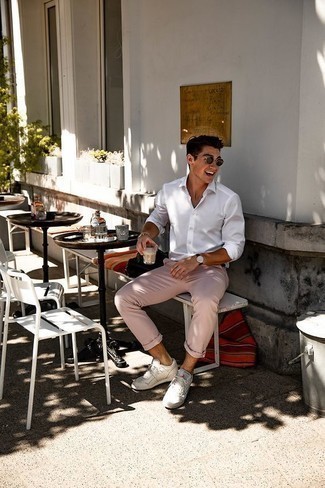 Tenue: Chemise à manches longues blanche, Pantalon chino rose, Baskets basses en cuir blanches, Lunettes de soleil marron foncé