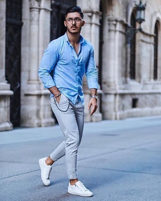 Comment porter une chemise à manches longues bleu clair: Associe une chemise à manches longues bleu clair avec un pantalon chino gris pour un look de tous les jours facile à porter. Jouez la carte décontractée pour les chaussures et fais d'une paire de baskets basses en toile blanches ton choix de souliers.