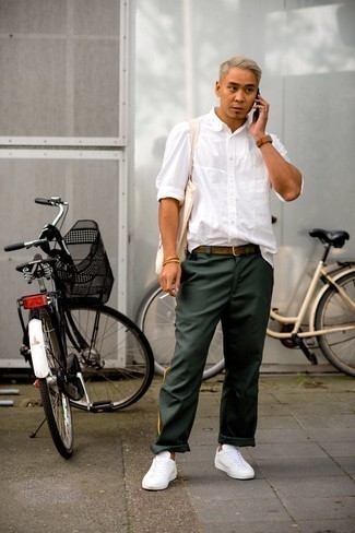 Tenue: Chemise à manches longues blanche, Pantalon chino vert foncé, Baskets basses en cuir blanches, Sac fourre-tout en toile imprimé beige