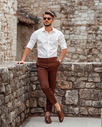 Comment porter des slippers en cuir marron: Pense à porter une chemise à manches longues blanche et un pantalon chino marron pour un look de tous les jours facile à porter. Rehausse cet ensemble avec une paire de slippers en cuir marron.