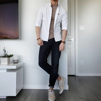 Comment porter une chemise à manches longues blanche: Pour une tenue de tous les jours pleine de caractère et de personnalité associe une chemise à manches longues blanche avec un jean noir. Assortis ce look avec une paire de baskets basses en toile beiges.