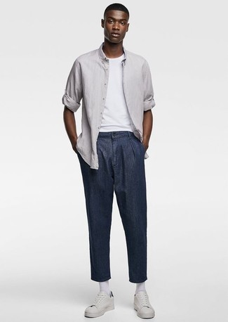 Tenue: Chemise à manches longues grise, T-shirt à col rond blanc, Pantalon chino bleu marine, Baskets basses en cuir blanches